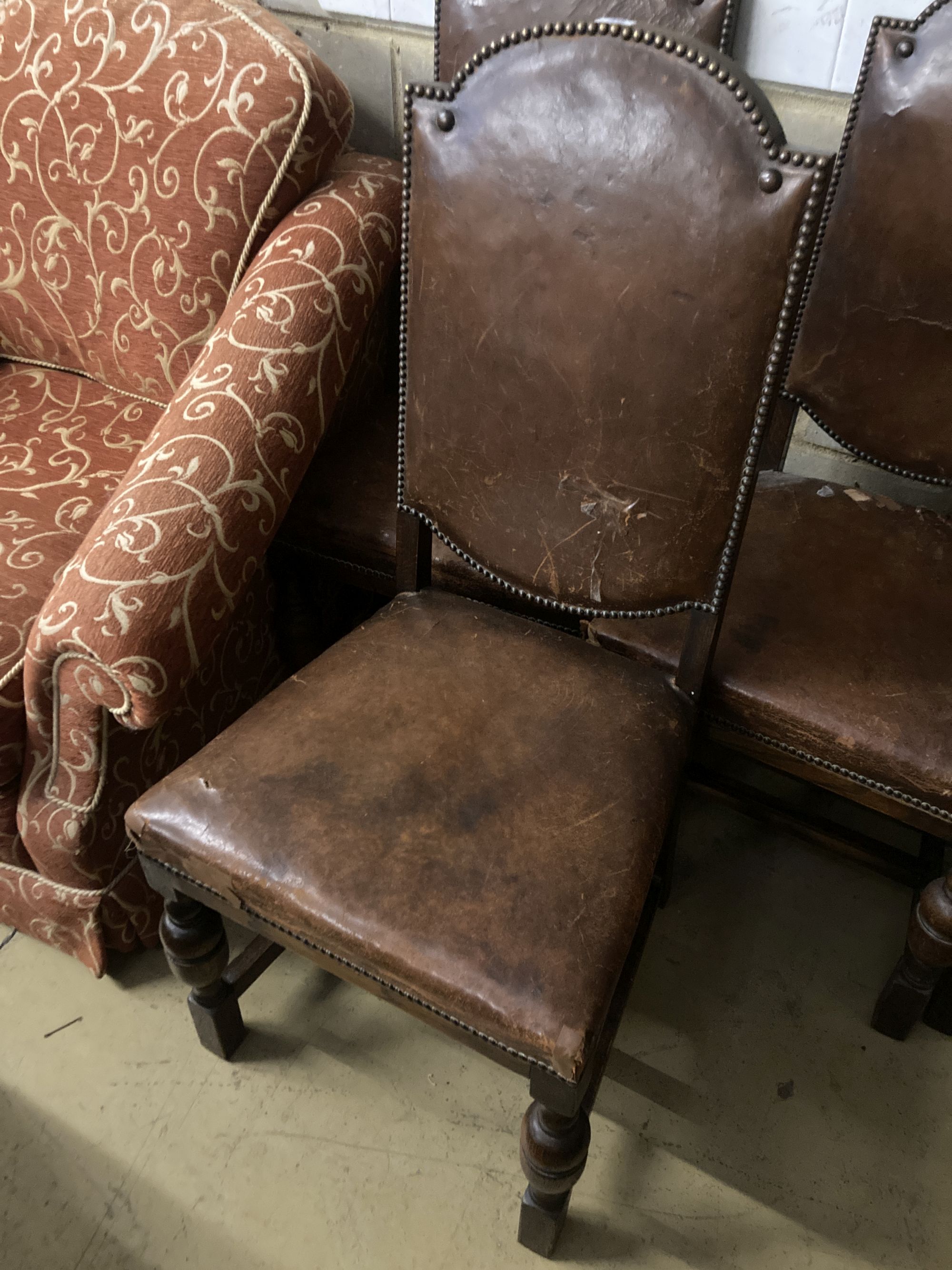 A set of four 1920s oak and tan leather dining chairs, height 109cm